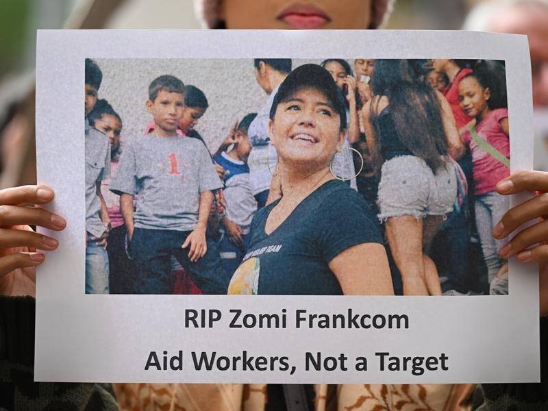 A protester holds a placard of Australian aid worker Zomi Frankcom, killed in an Israeli airstrike. (James Ross/AAP PHOTOS)