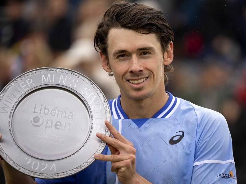 Alex de Minaur poses with the winner's trophy after his victory over Sebastian Korda in Rosmalen. (EPA PHOTO)